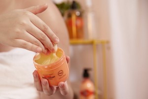 Hand scooping The Body Shop Mango Body Yogurt Hand scooping The Body Shop Mango Body Yogurt